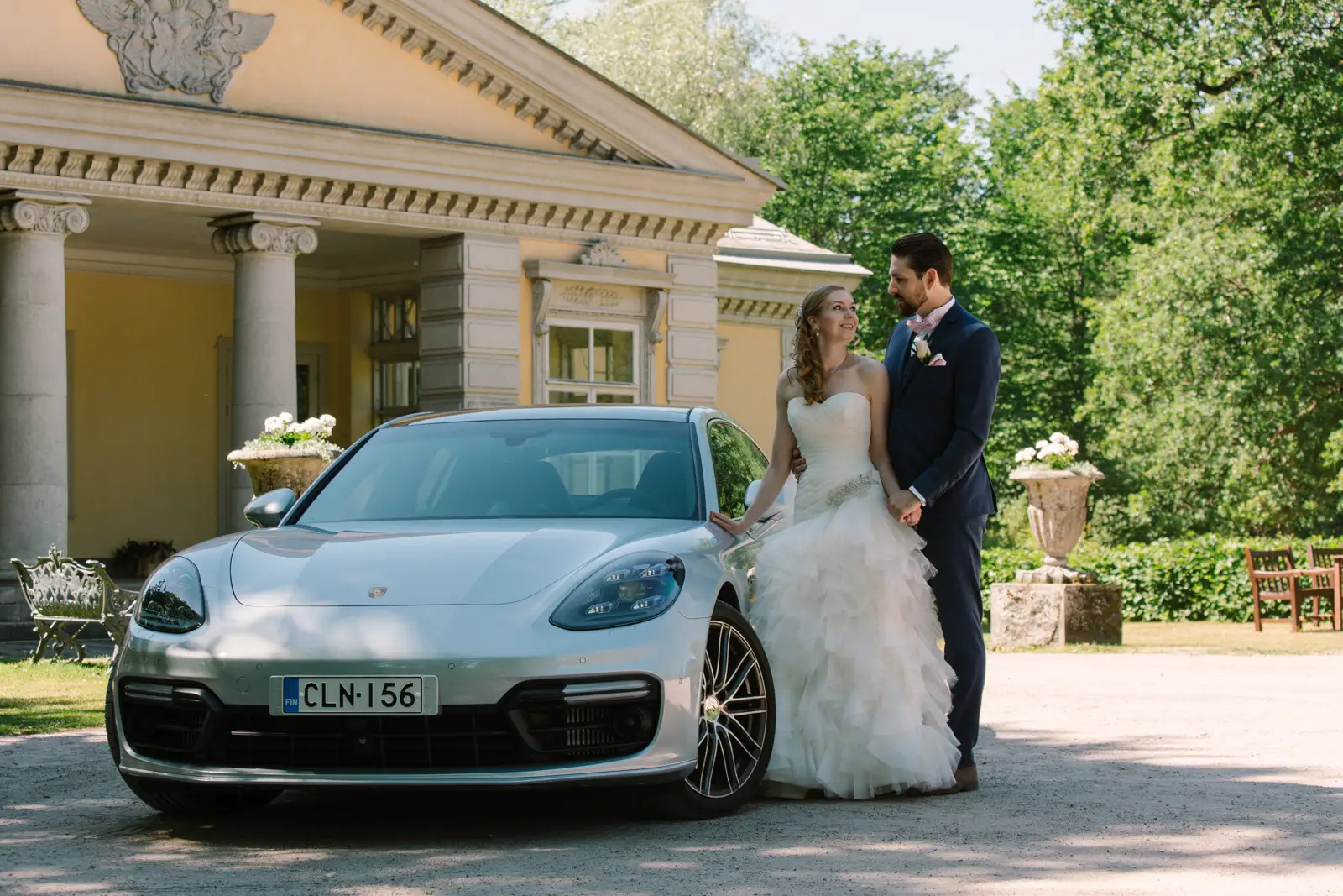Wedding pair standing by a Porsche